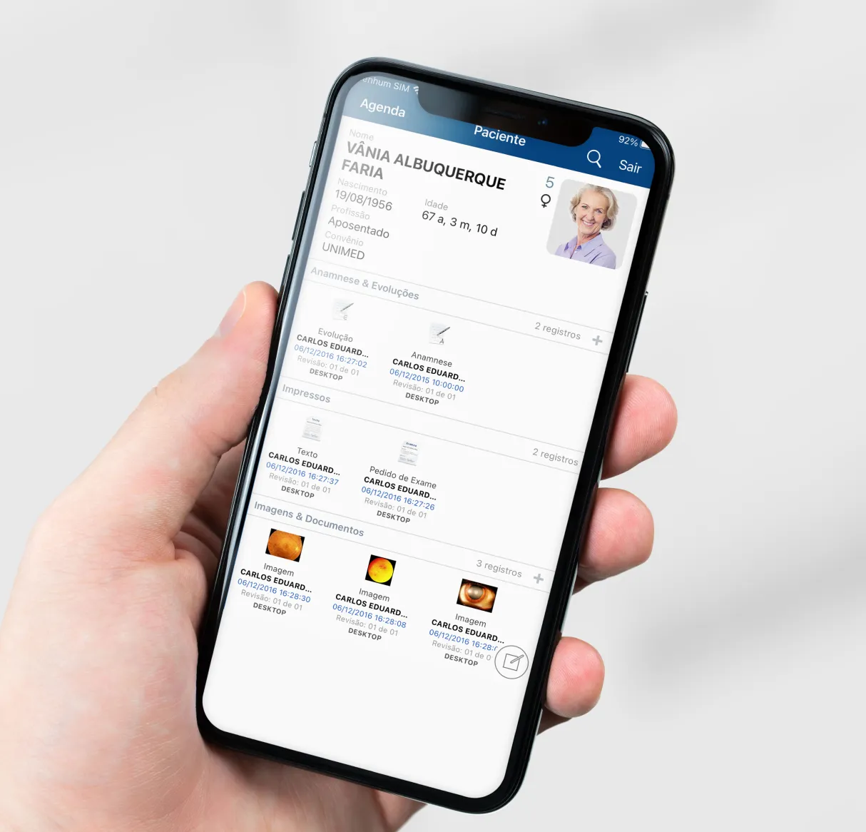 Mão segurando um celular com app do corp