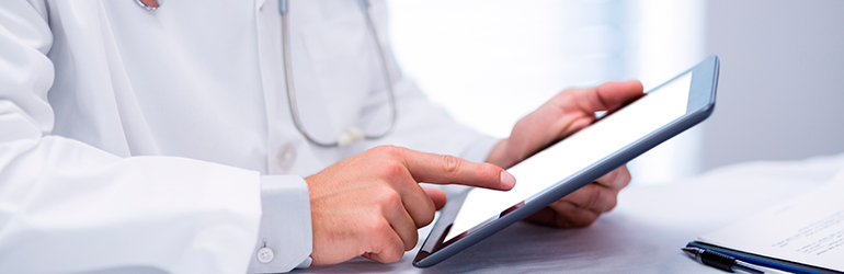 Médico toca a tela de um tablet para ilustrar o texto dos erros na administração de clínicas e consultórios.