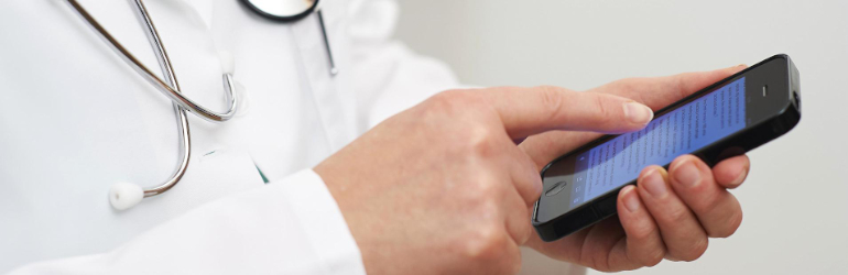 Médico manuseia um smartphone - Dia do Médico: aplicativos para facilitar a vida dos médicos