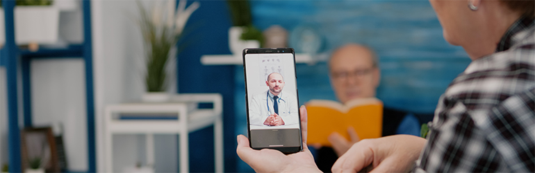 Regulamentação da telemedicina: imagem mostra uma idosa realizando teleconsulta pelo smartphone com um médico.