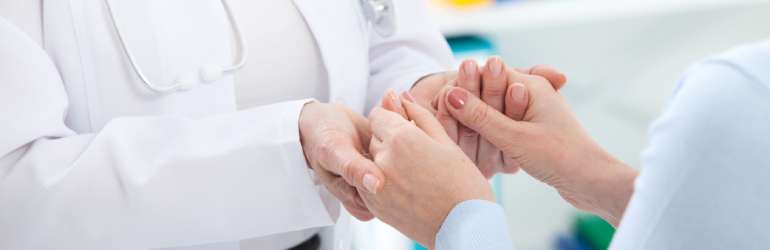 médica dá as mãos a uma paciente em sinal de confiança - principais erros médicos e como evitar