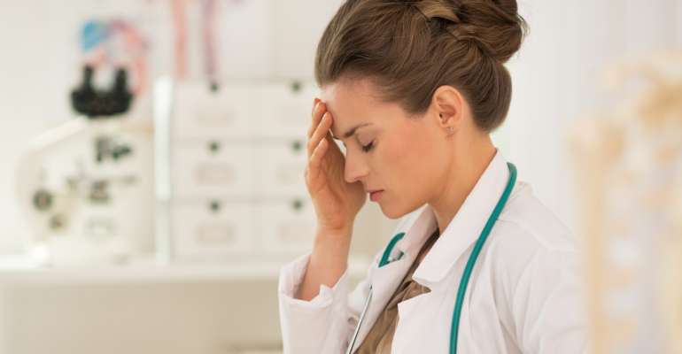 principais erros médicos: médica com semblante de preocupação num consultório