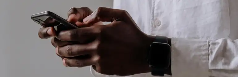 Pessoa manipulando um smartphone com as mãos, foco nas funcionalidades de um sistema de agendamento online.