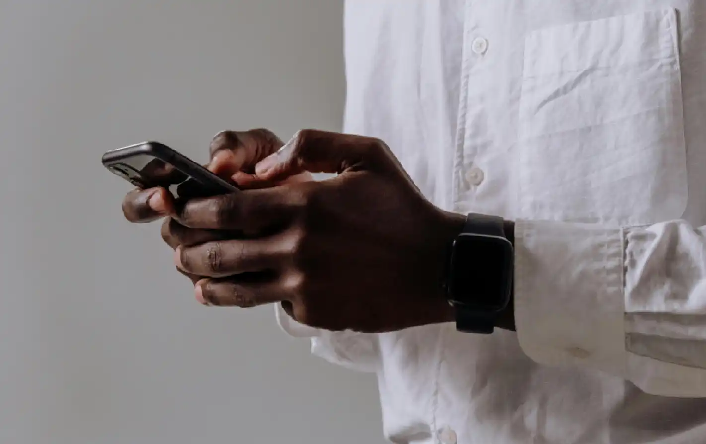Homem usando smartphone em um ambiente moderno, enfatizando a conexão digital e a tecnologia no dia a dia.