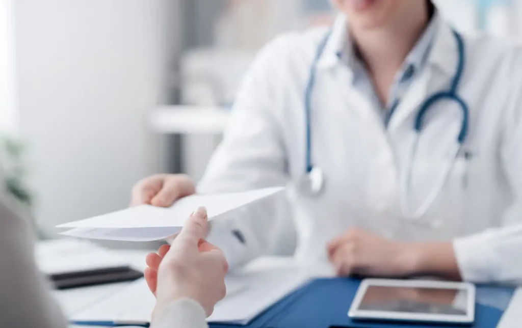 Profissional de saúde entregando prescrição com cálculo de medicamento a paciente em ambiente de clínica ou consultório.