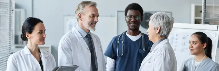 Equipe médica diversificada em um ambiente de clínica, demonstrando a responsabilidade médica no trabalho em equipe.