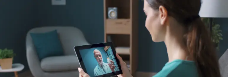 Mulher usando tablet para uma consulta por telemedicina com um profissional de saúde de uma clínica ou consultório preparada para atender pacientes da desospitalização.